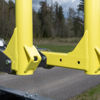 Zbliżenie na żółte ramiona nośne podnośnika warsztatowego z otworami montażowymi i elementami mocującymi