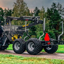 Czerwono-czarny forwarder leśny na kołach z żurawiem hydraulicznym do załadunku drewna na tle lasu