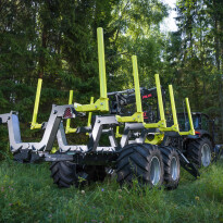 Zielono-żółta przyczepa leśna z hydraulicznym żurawiem i kłonicami do przewozu bali drewna na tle lasu